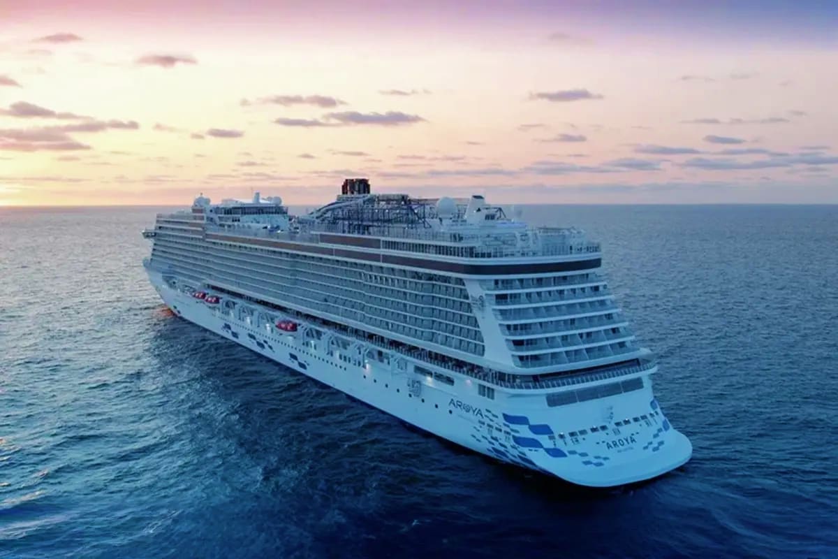Aroya Jeddah Roundtrip Cruise Large white cruise ship Aroya anchored in open ocean during sunset with calm blue waters and clouds on horizon