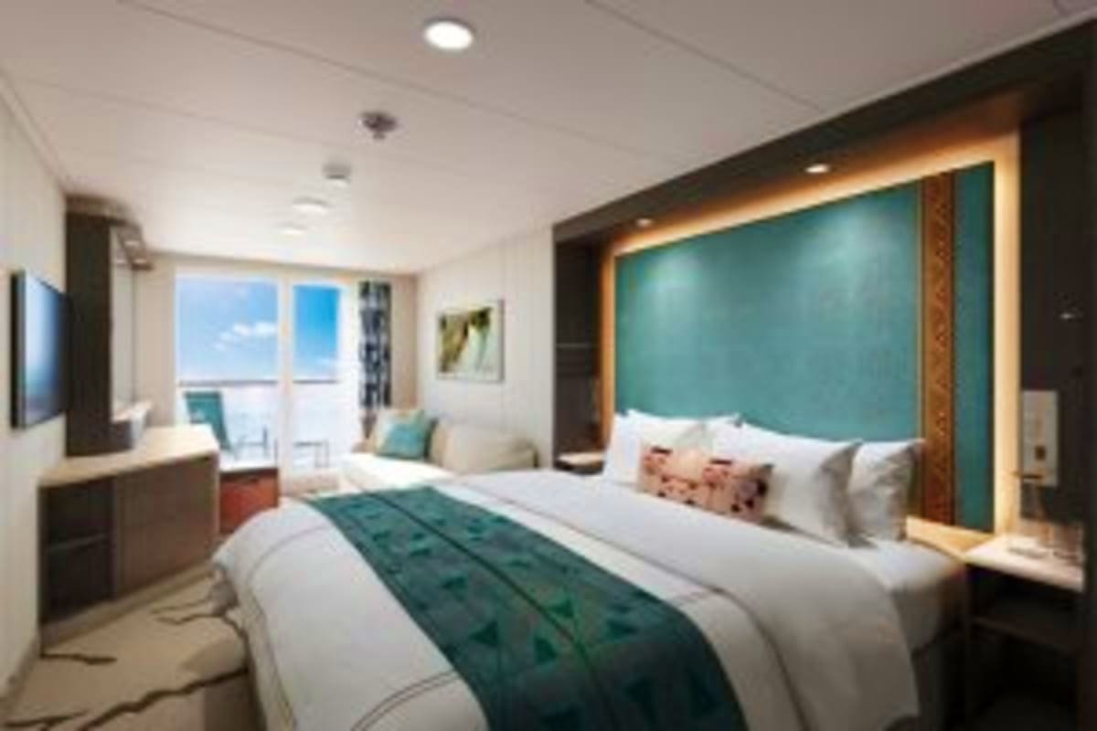 Modern cruise ship stateroom with queen bed, teal headboard, ocean view balcony, and contemporary furnishings