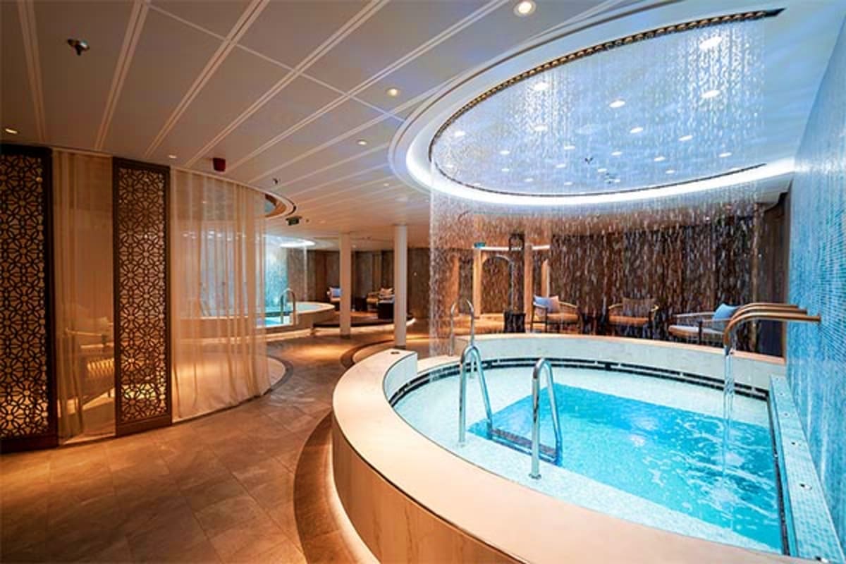 Aroya Jeddah Roundtrip Cruise Luxury cruise ship spa with circular hot tub, blue mosaic tiles, curved ceiling with starlight fixture, and lounge seating ar