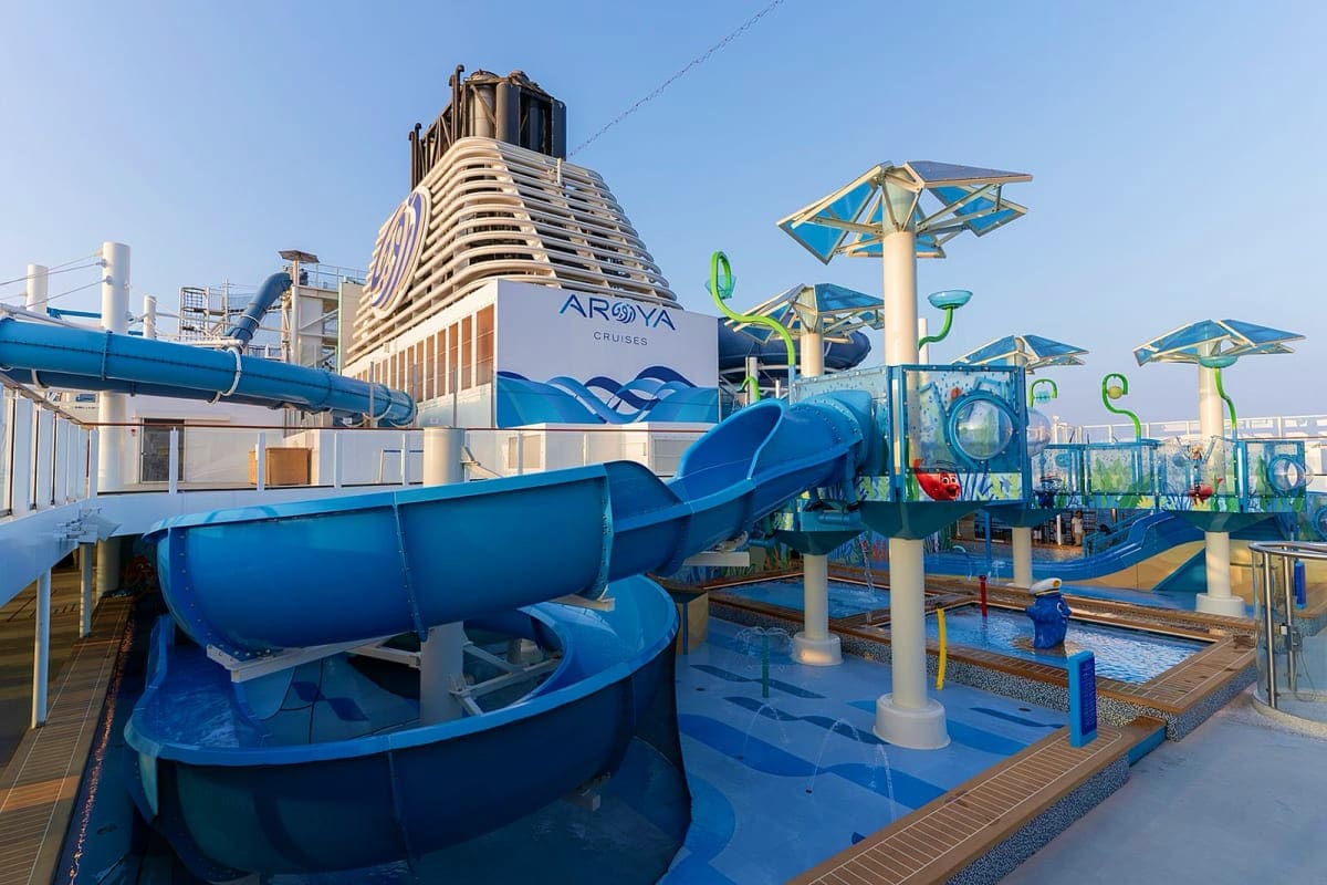 Aroya cruise ship with blue waterslide and kids play area on deck under clear sky