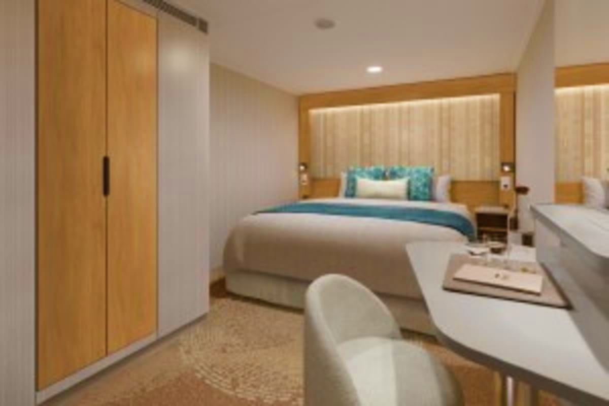 Aroya Red Sea Egypt Explorer Cruise. Modern cruise ship cabin with queen bed, teal bedding, wooden wardrobe, white desk, and large window with curtains