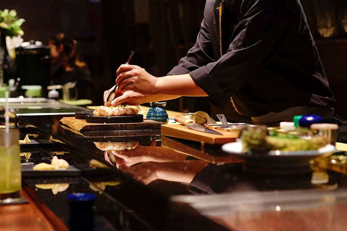 Chef preparing sushi at counter during onboard dining experience on Aroya Aqaba Sailing Cruise