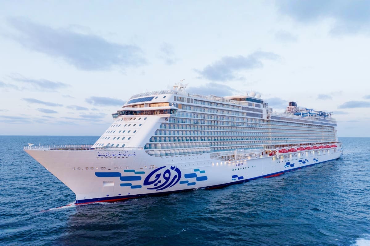 Large white cruise ship Aqoya sailing on blue ocean water under cloudy sky