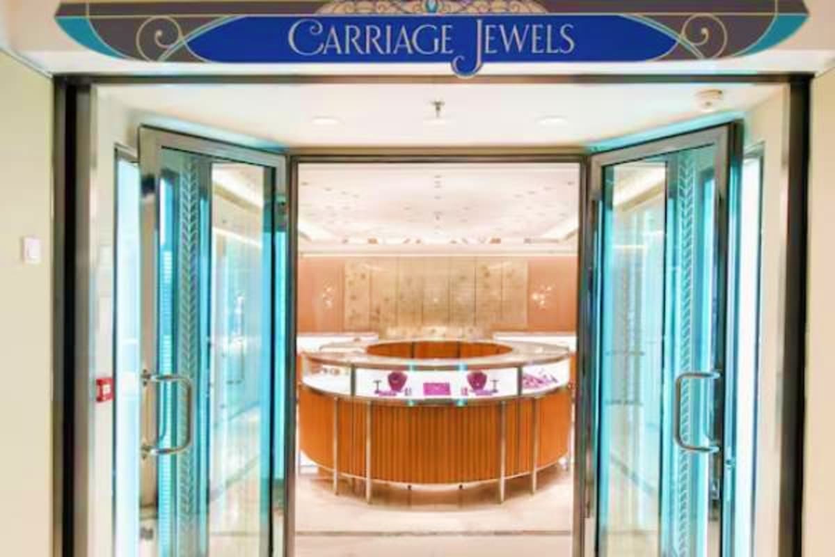 Carriage Jewels jewelry store entrance with turquoise framed glass doors and circular display counter inside a cruise ship