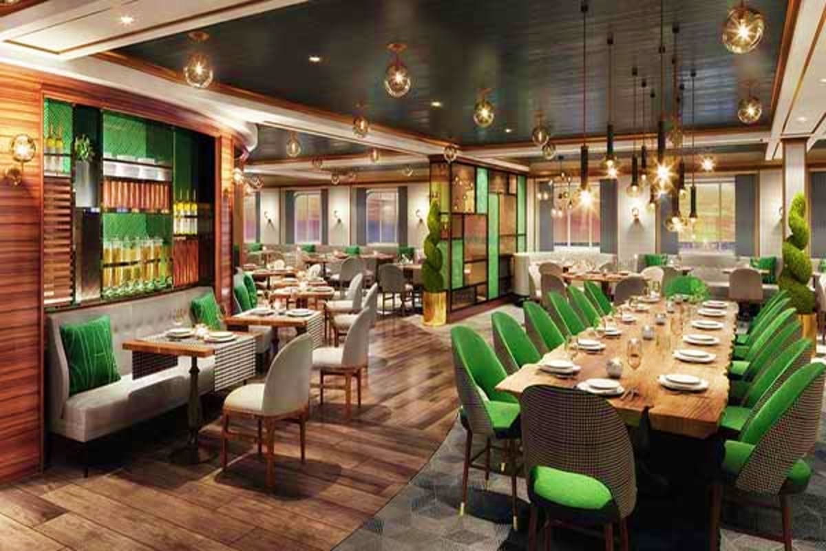 Modern restaurant dining area with long wooden tables, green striped chairs, pendant lighting, and floor-to-ceiling windows o
