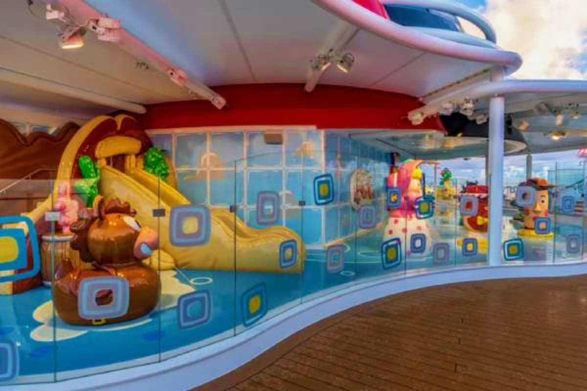 Colorful children's play area inside Disney Treasure cruise ship with inflatable toys and ocean-themed wall murals