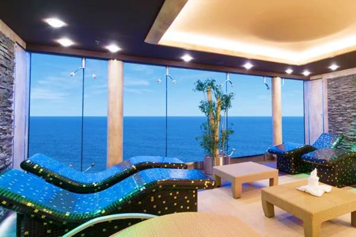 MSC Preziosa Northern Escape Luxury spa room with ocean views on MSC Preziosa cruise ship featuring blue loungers and floor-to-ceiling windows overlooking