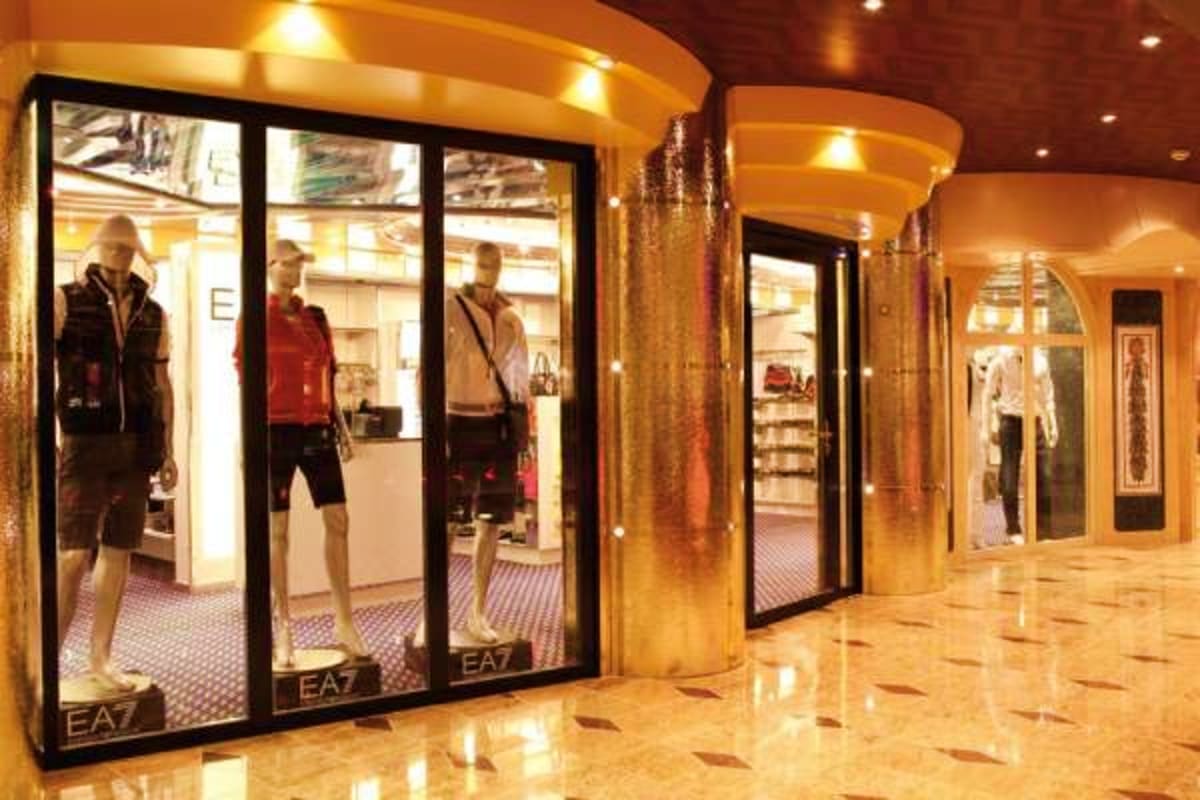 EA7 luxury fashion store storefront on Costa Fascinosa cruise ship with mannequins displaying athletic wear in illuminated di