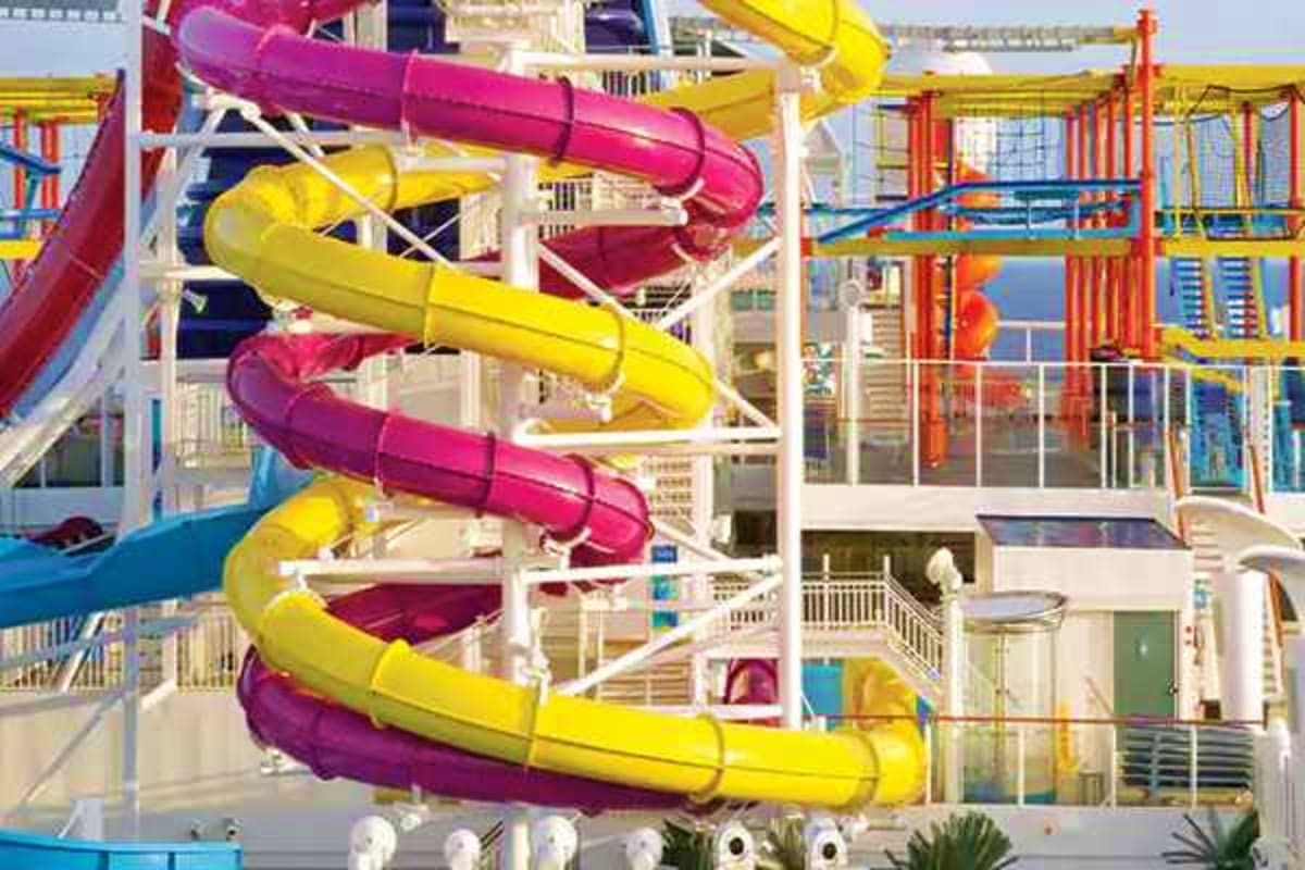 Norwegian Breakaway New England Escape Colorful water slides with pink and yellow tubes on a cruise ship deck overlooking the ocean