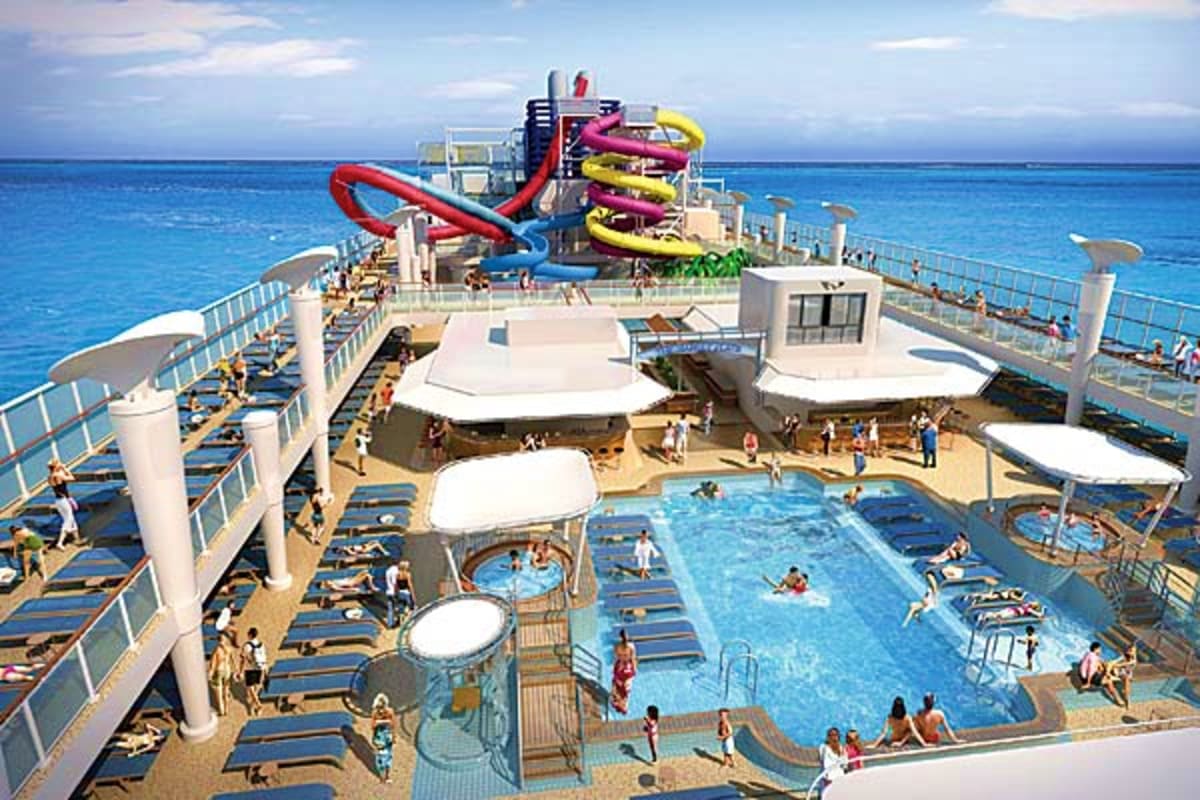 Aerial view of Norwegian Breakaway cruise ship deck with swimming pool, water slides, lounge chairs, and ocean in background