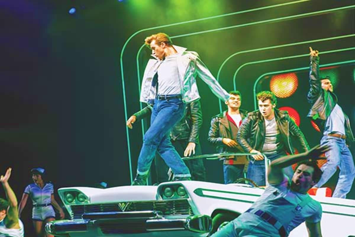 Animated illustration of young men dancing on a white car with neon green stage lighting and geometric backdrop design
