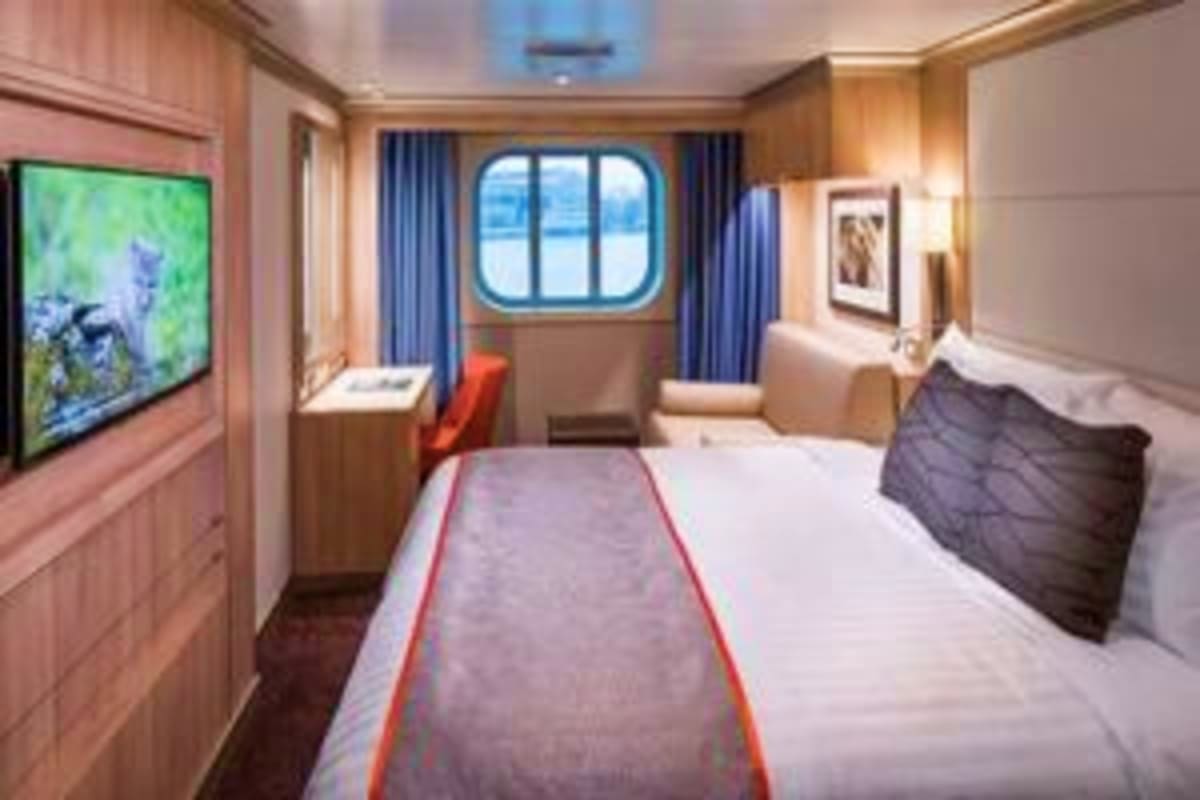 Nieuw Statendam Norway Voyage Luxurious cruise ship stateroom with queen bed, flat-screen TV, porthole window with ocean view, and modern wood paneling thr