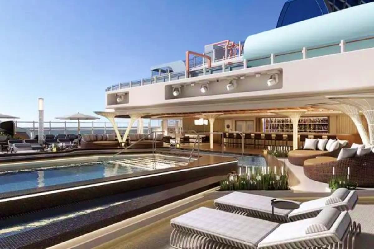 Luxury cruise ship deck with swimming pool, lounge chairs, bar area, and ocean views under clear blue sky