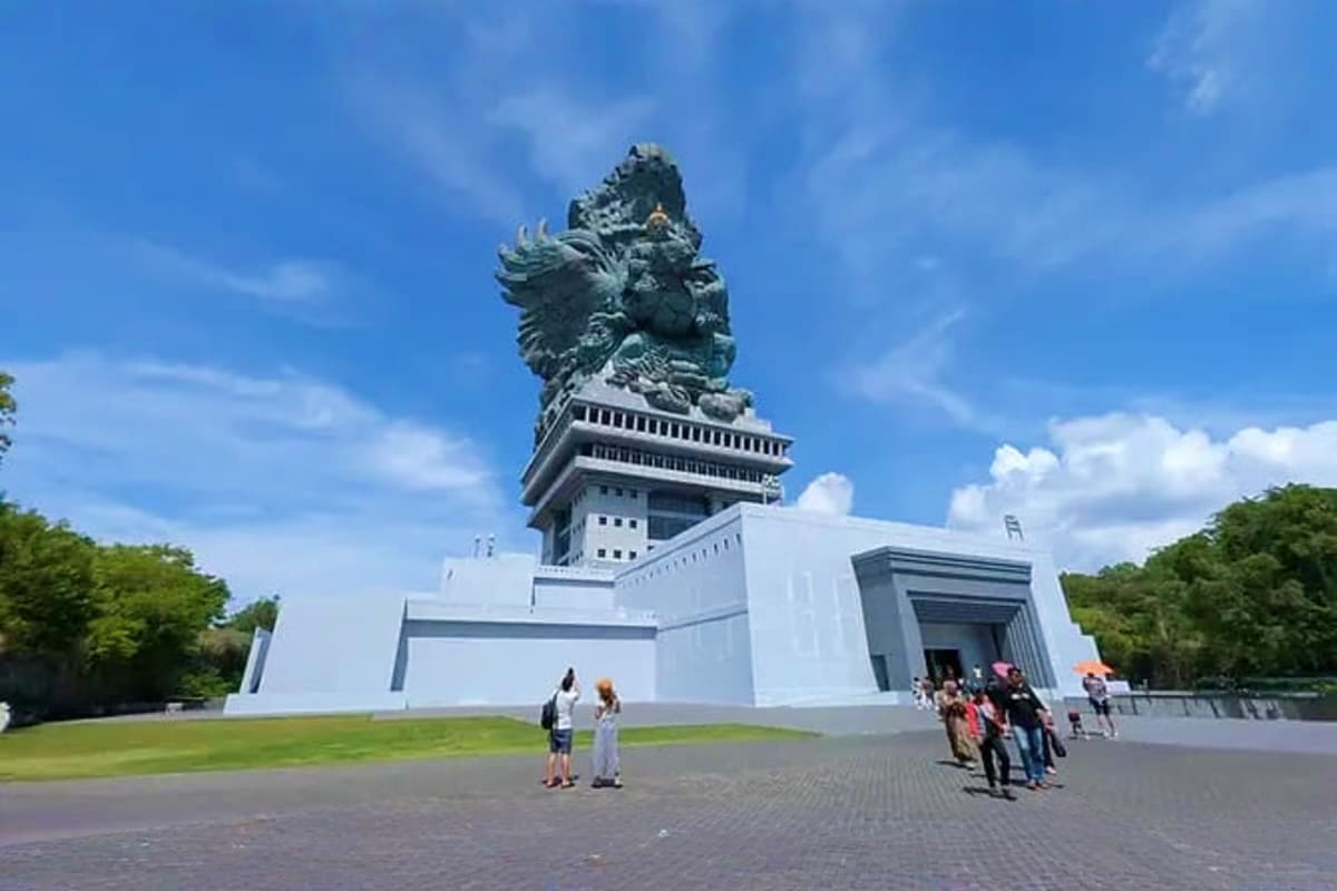 Giant stone Garuda Wisnu Kencana statue and monument pavilion with visitors in Bali, Indonesia