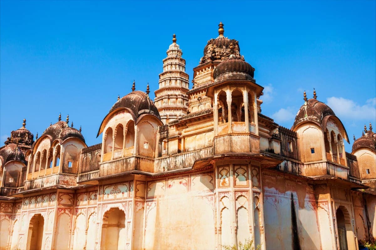 Historic sandstone palace with ornate domes and carved arches against blue sky in Rajasthan, India
