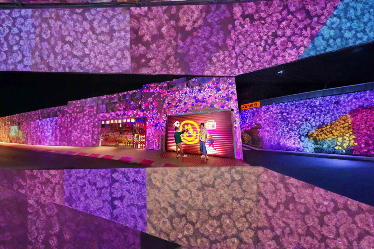 Ultimate Dubai Explorer Immersive digital art installation with vibrant purple flower projections and neon signage in modern gallery space