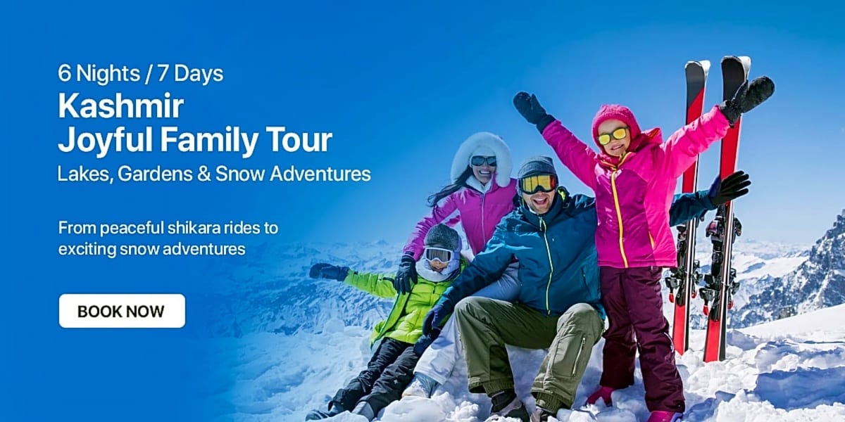 Happy family of four in colorful winter clothing posing in snow-covered mountains with ski equipment and blue sky background
