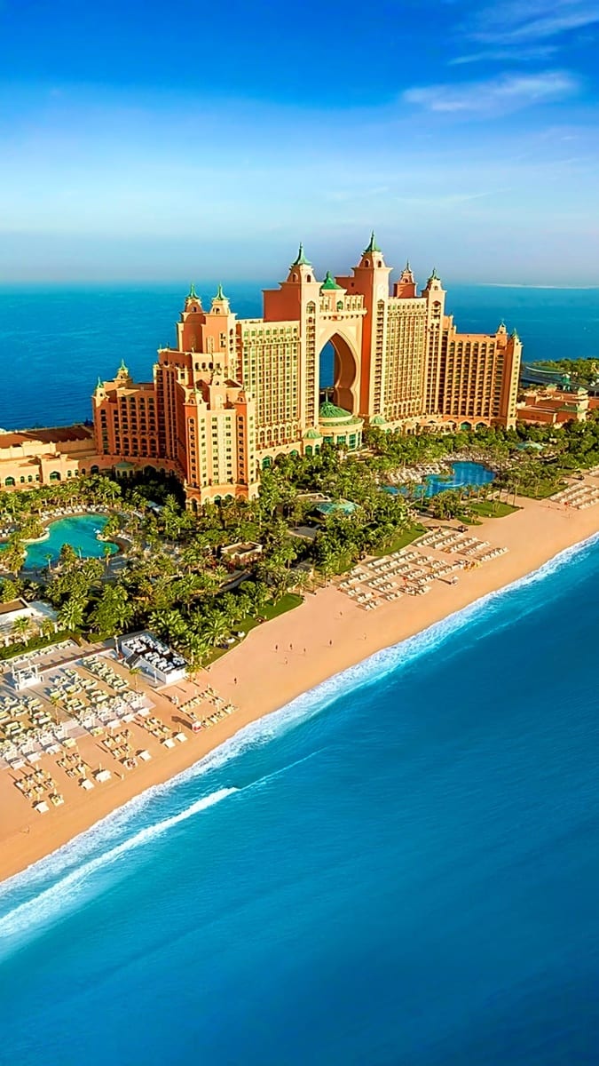 Aerial view of Atlantis The Palm luxury resort in Dubai with turquoise ocean, sandy beach, and palm-shaped island