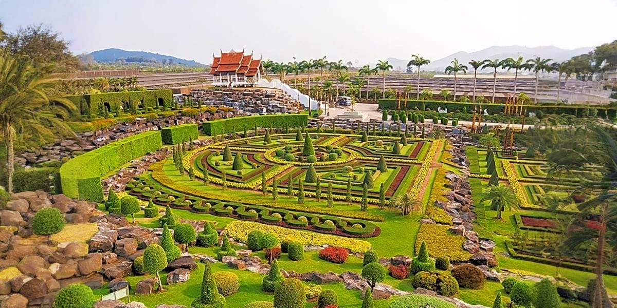 Aerial view of Nong Nooch Tropical Garden's ornate hedge maze with Thai temple pavilion and manicured landscapes in Pattaya, 