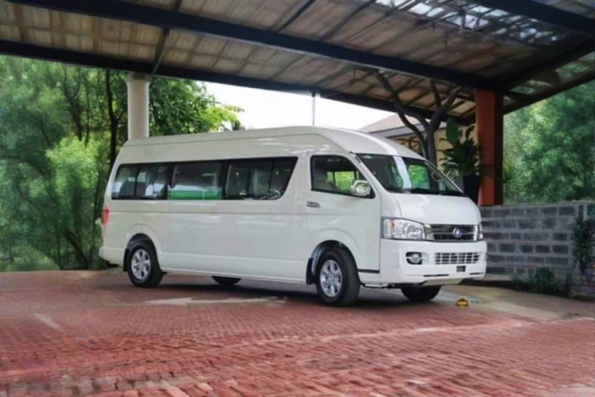 Krabi Hotel to Phuket Hotel White passenger van parked under covered carport with brick driveway and green foliage surroundings