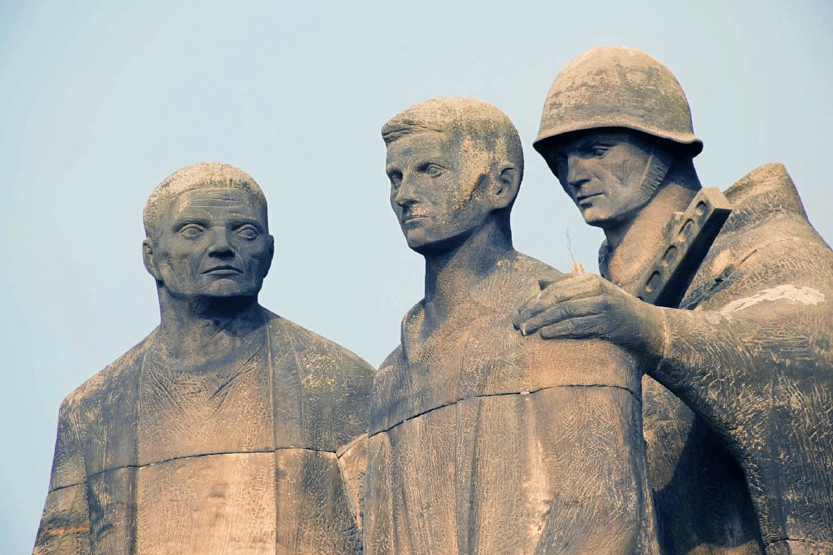 Stone monument depicting three male figures representing victims of Sachsenhausen concentration camp memorial site