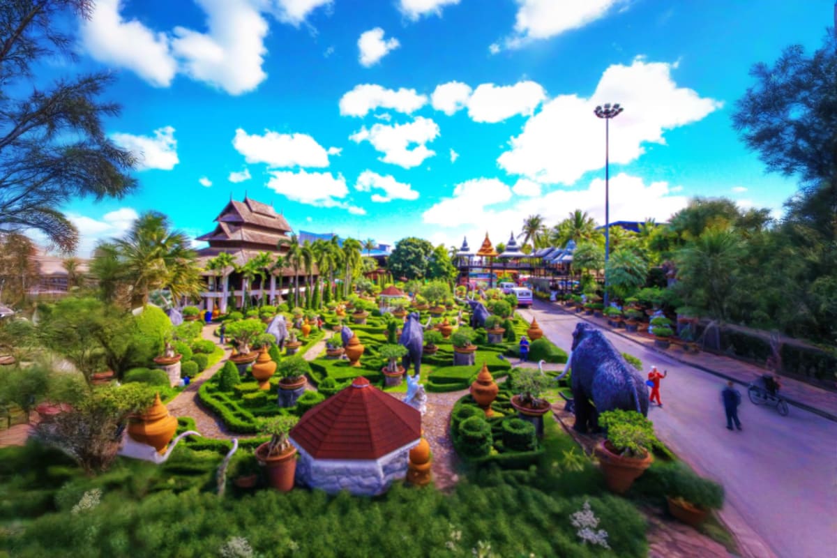 Aerial view of Nong Nooch Tropical Garden with manicured green landscapes, traditional Thai architecture, temple buildings, a