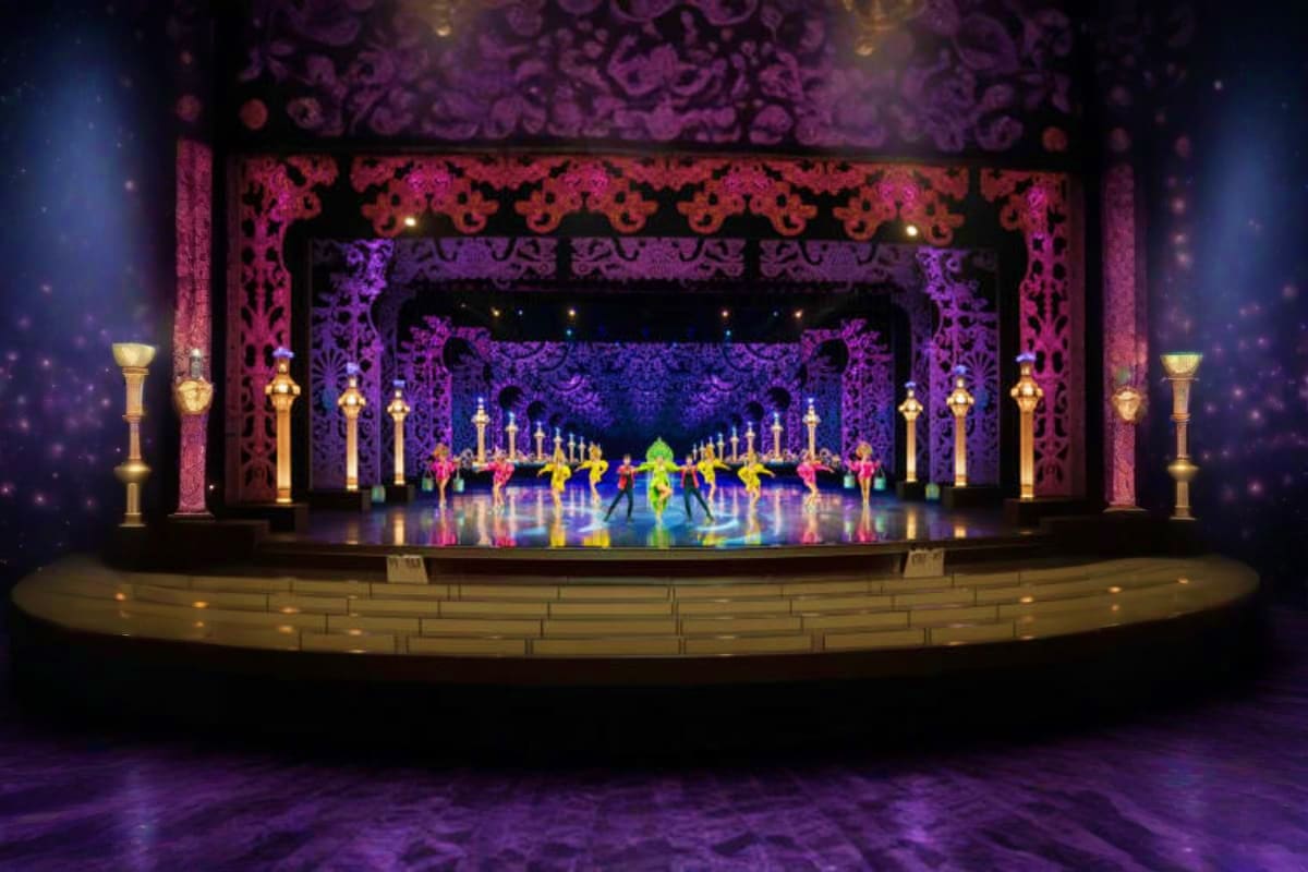 Colosseum Show Pattaya Ornate theater stage with elaborate pink and purple decorative archways, gold columns, and performers in colorful costumes da