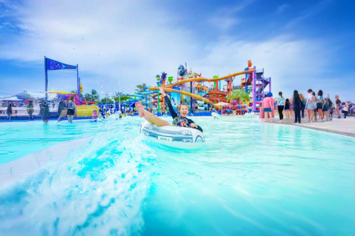Child floating on inflatable in wave pool at Columbia Pictures Aquaverse Waterpark with colorful water slides and attractions
