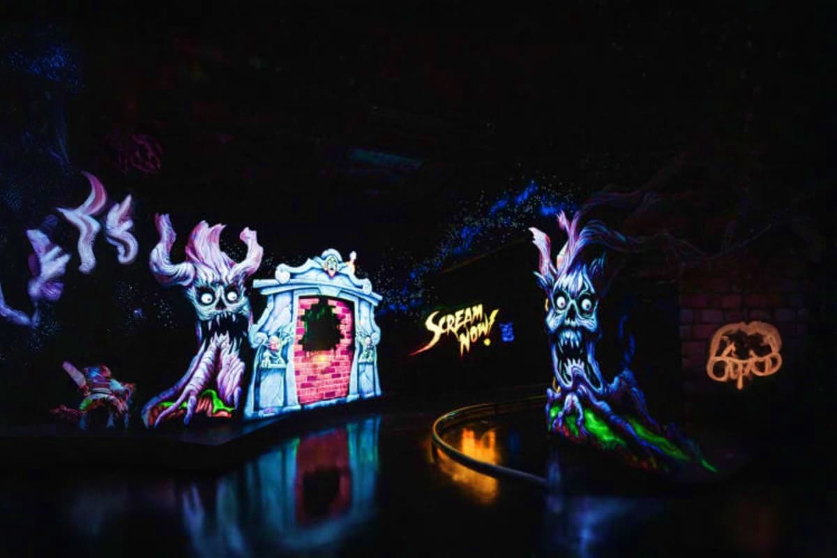 Neon glowing haunted house display with creepy monster figures and "Scream Now" text at Ripley's Believe It or Not attraction
