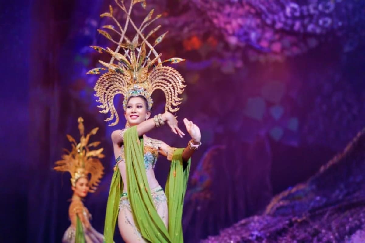 Thai dancer in elaborate gold headdress and green silk costume performing at Alcazar Show theatrical stage production