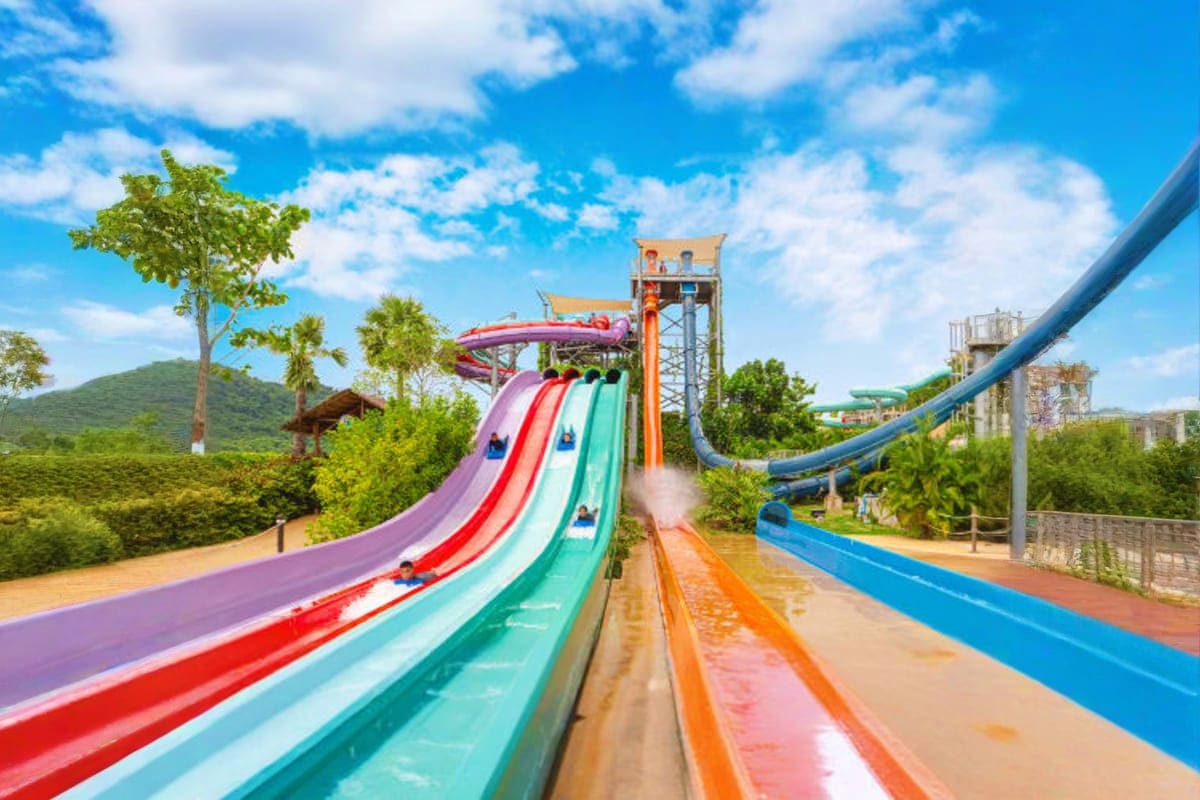 Colorful water slides at Ramayana Water Park with tropical landscape and blue sky in background