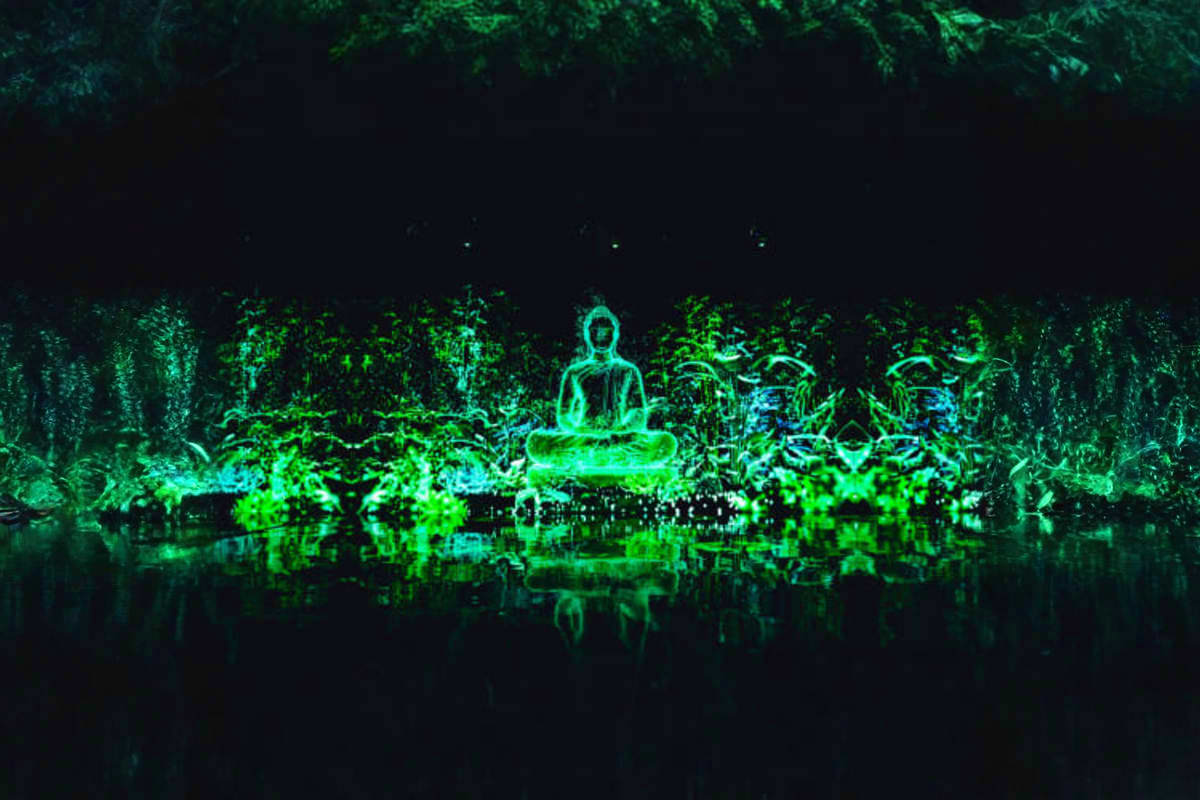 Glowing neon figure in meditation pose surrounded by luminescent green foliage and water reflection in dark forest setting