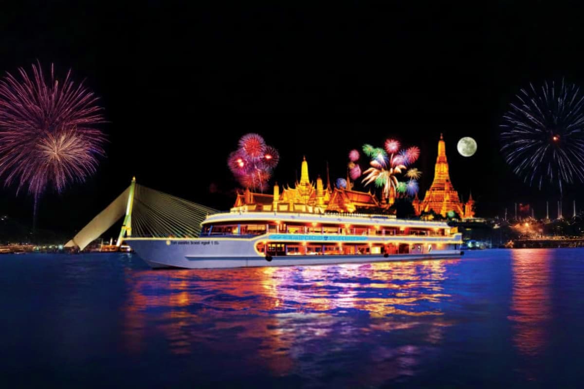 Illuminated dinner cruise boat on the Chao Phraya River with Thai temples lit up in background, fireworks, and full moon at n