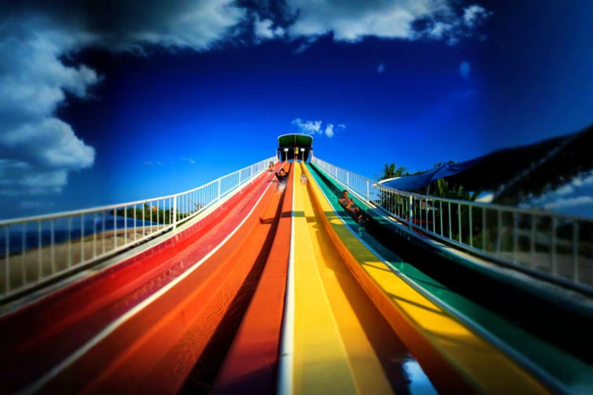 Colorful water slide lanes at Siam Amazing Park Bangkok with blue sky and clouds in background
