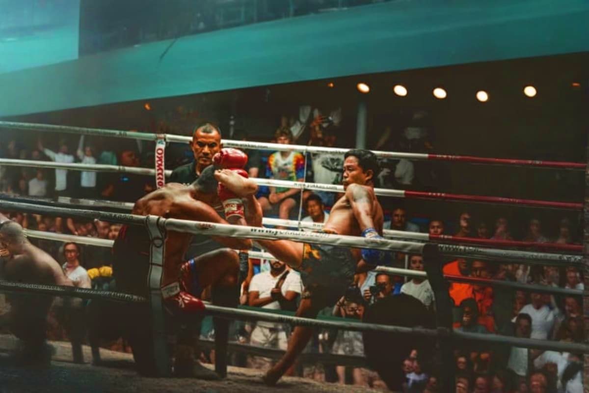 Patong Boxing Stadium Two boxers fighting in a professional ring at Patong Boxing Stadium with spectators watching from the stands and referees off