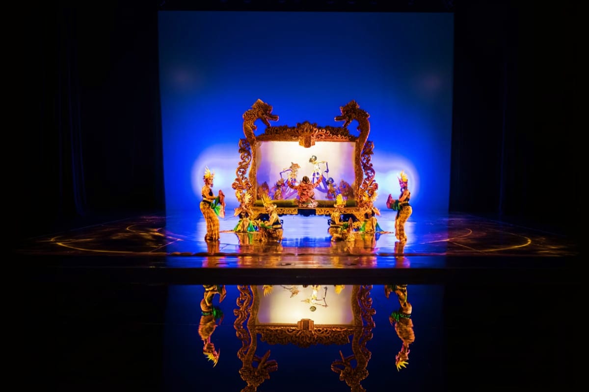 Elaborate golden dragon-framed stage with performers in traditional costumes under blue lighting at the Devdan Show theater p