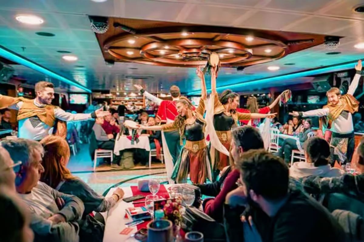 Dancers performing on stage during a Bosphorus dinner cruise with guests seated at dining tables under decorative lighting