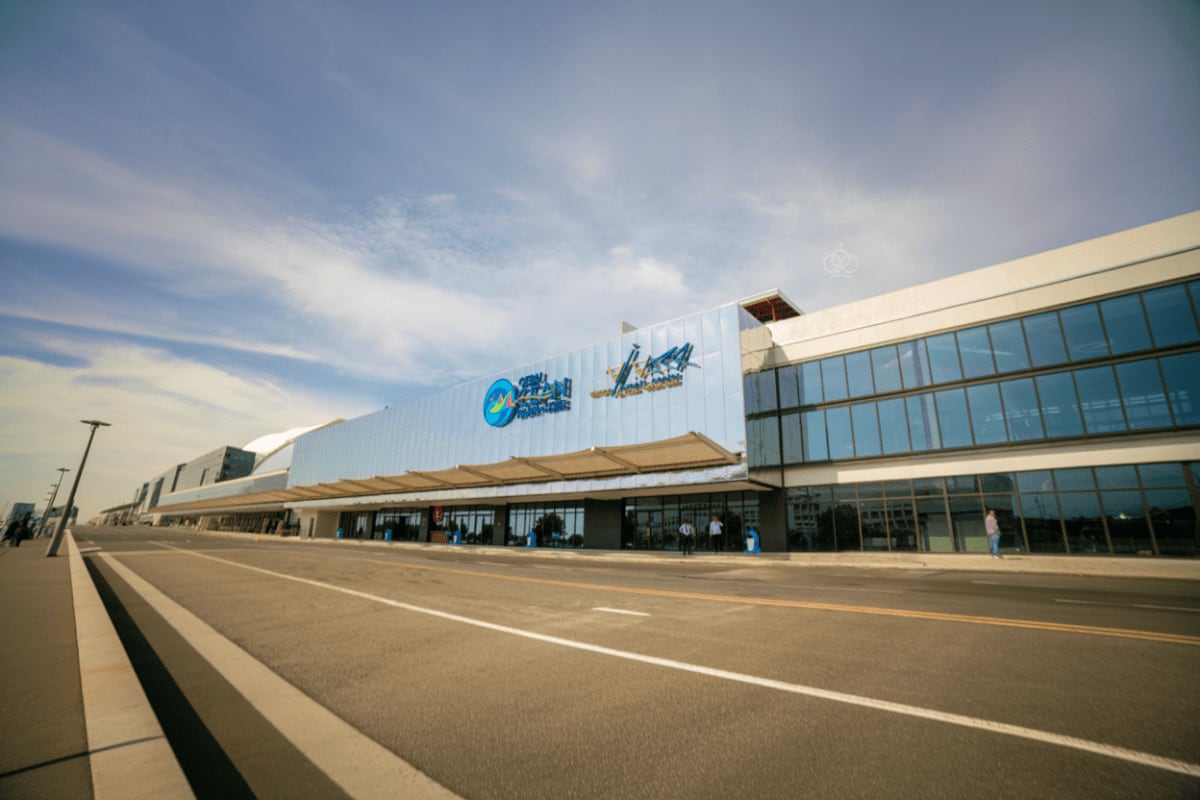 Exterior view of Cebu Ocean Park building with modern white facade, blue circular logo, and glass entrance on a clear day