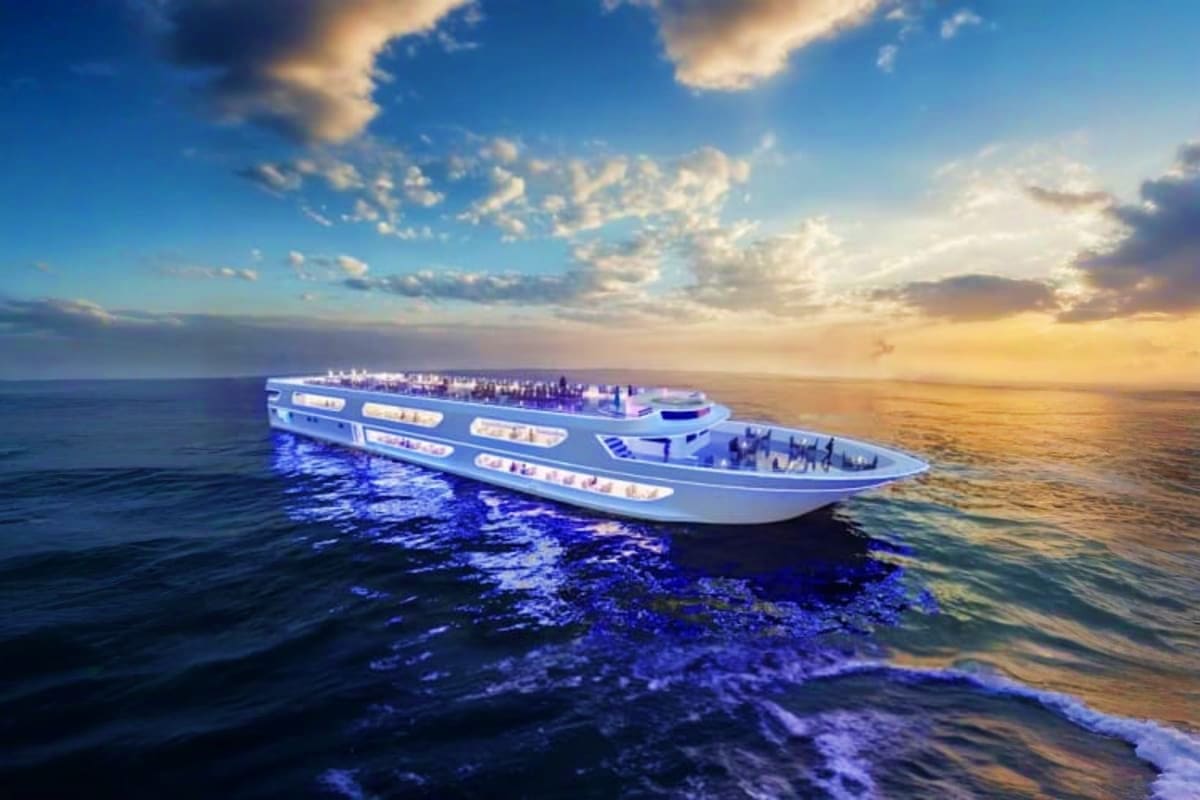 Large modern cruise ship with blue lighting anchored in calm ocean waters at sunset with golden sky and clouds