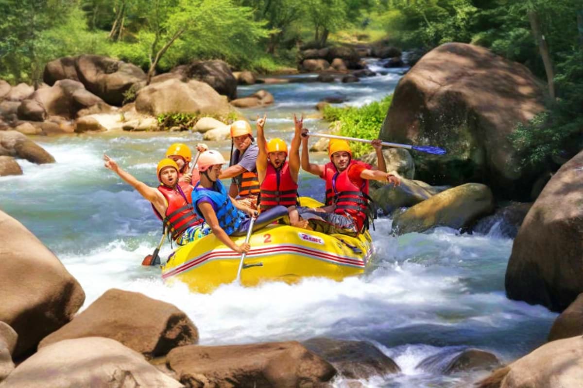 White Water Rafting Group of people white water rafting in yellow raft on river with large boulders and forested banks