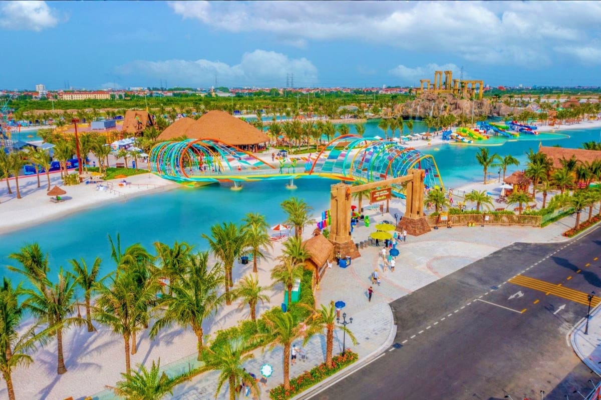 Aerial view of VinWonders Water Park with colorful water slides, turquoise pools, palm trees, and ancient temple-inspired arc