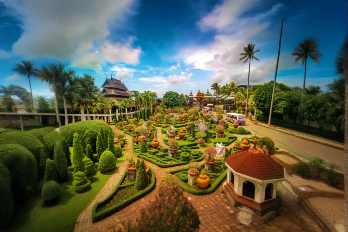 Aerial view of Nong Nooch Tropical Garden featuring manicured green hedges, ornamental gardens, traditional Thai temples, and