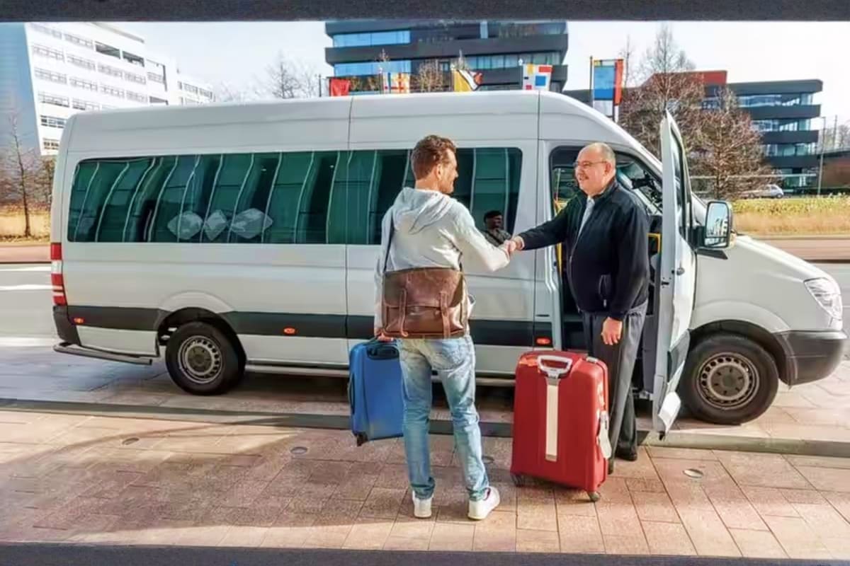 Passenger with luggage boarding a white shuttle van for airport transportation service