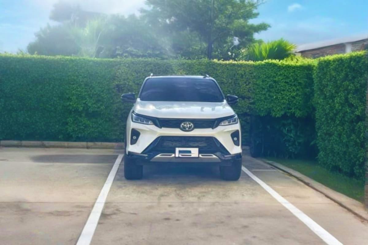 White Toyota SUV parked in driveway with green hedges, airport transfer vehicle for Chiang Rai pickup service