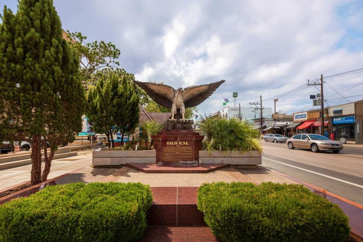 Enroute Krabi city tour to Phuket Public monument with large bronze eagle statue in Krabi city center along the highway with shops and vehicles