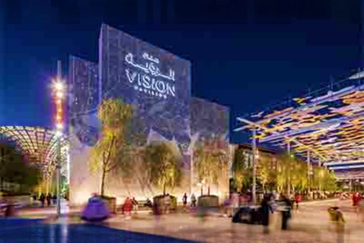 Illuminated Vision pavilion at Expo City Dubai at night with landscaped plaza, visitors, and modern architecture