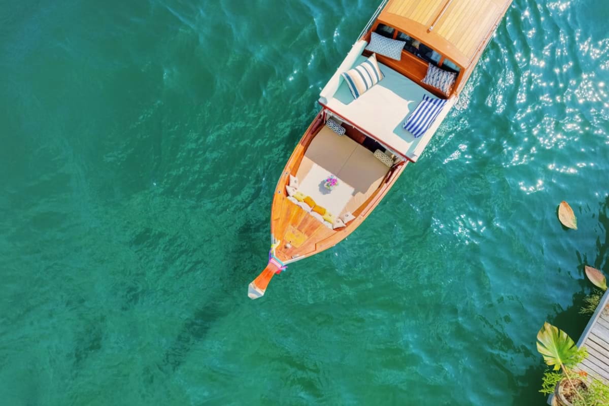 Aerial view of wooden long tail boat moored in turquoise water near Hong Island, Thailand