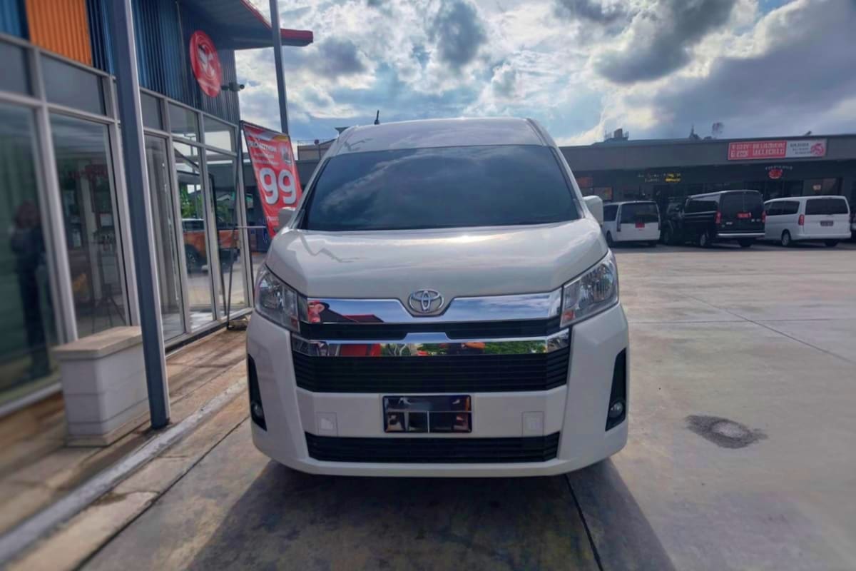 White Toyota van parked outside hotel entrance for airport transfer service in Pattaya