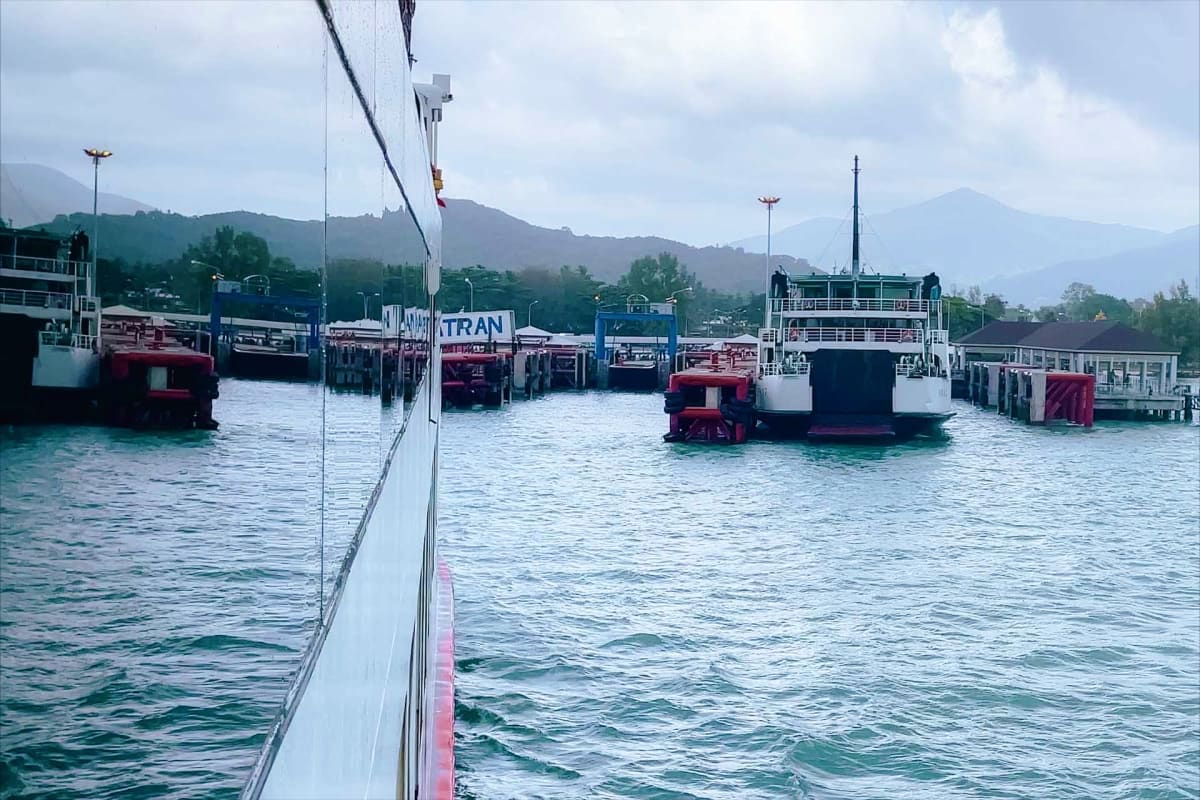Koh Samui to Surat Thani Ferry Transfers Ferry boats docked at Koh Samui pier with mountains in background, showing TRAN transport service vessels ready for passenger