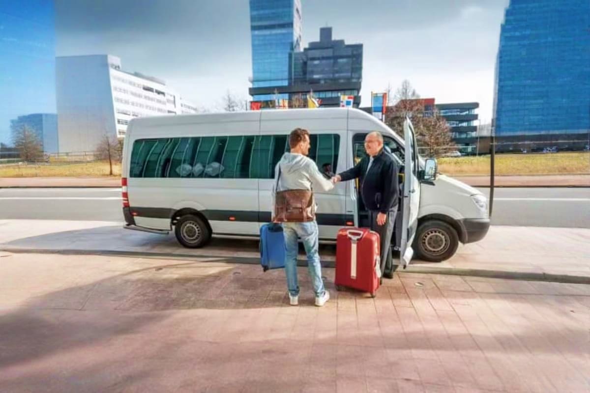 Private Vehicle Half Day With Driver Passenger boarding white minivan with driver in urban setting with modern office buildings in background